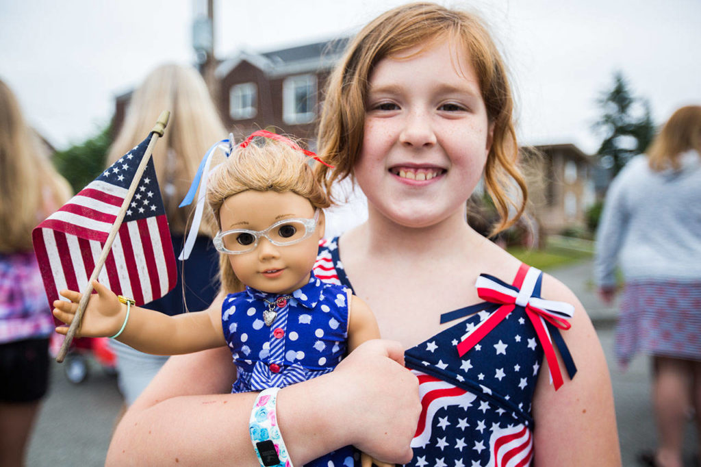 Rory Moen, 9, poses for a portrait with her dressed up American Girl doll during the Colors of Freedom Fourth of July Parade on Thursday, July 4, 2019 in Everett, Wash. (Olivia Vanni / The Herald)
