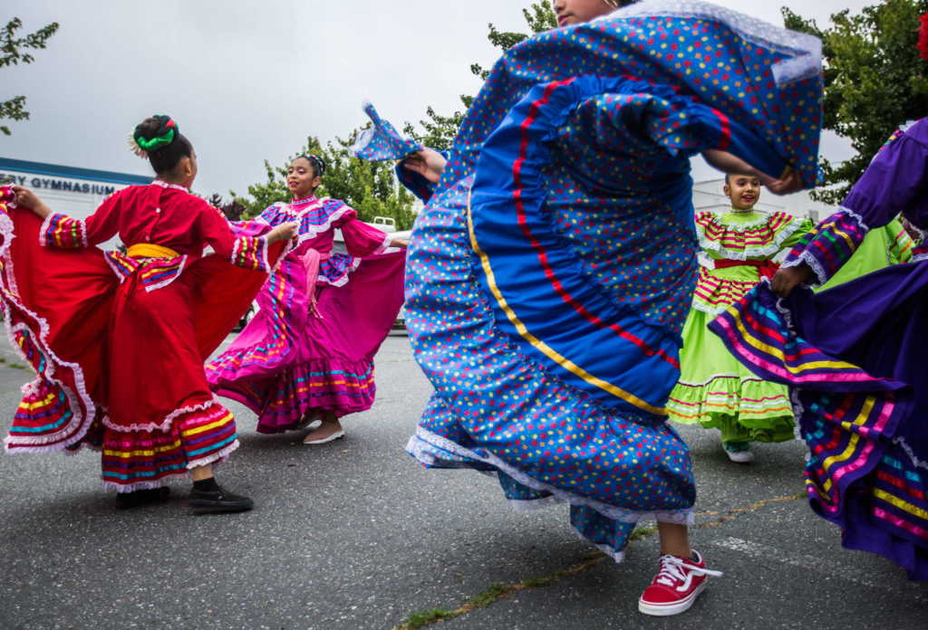 Baile Folklore Colibri members dance in the Everett High School parking lot before the start of the Colors of Freedom Fourth of July Parade on Thursday, July 4, 2019 in Everett, Wash. (Olivia Vanni / The Herald)
