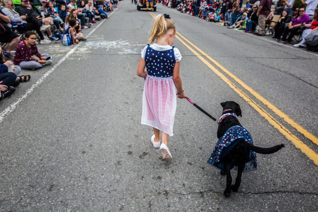 Clara Harper, 5, walks Laila, a Labrador retriever, during the Colors of Freedom Fourth of July Parade on Thursday, July 4, 2019 in Everett, Wash. (Olivia Vanni / The Herald)
