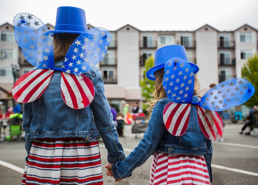 Audri Acosta, 8, and Valentina Acosta, 4, pose for a picture of their watching American flag fairy wings during the Colors of Freedom Fourth of July Parade on Thursday, July 4, 2019 in Everett, Wash. (Olivia Vanni / The Herald)
