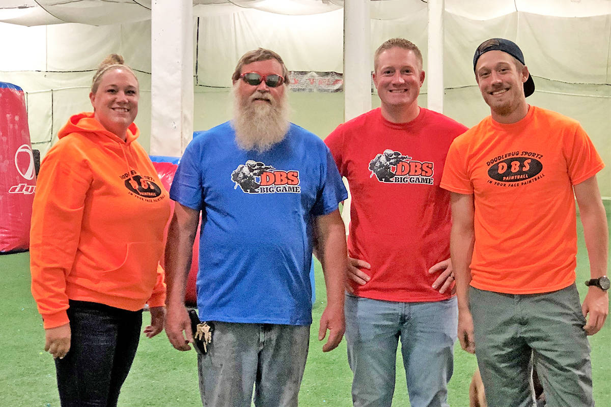 Dawn Bennett, dad Don Cort and brothers Danny and Dusty gather for a family photo at the indoor arena at Doodlebug Sportz Paintball, their family-run business in Everett and Snohomish.