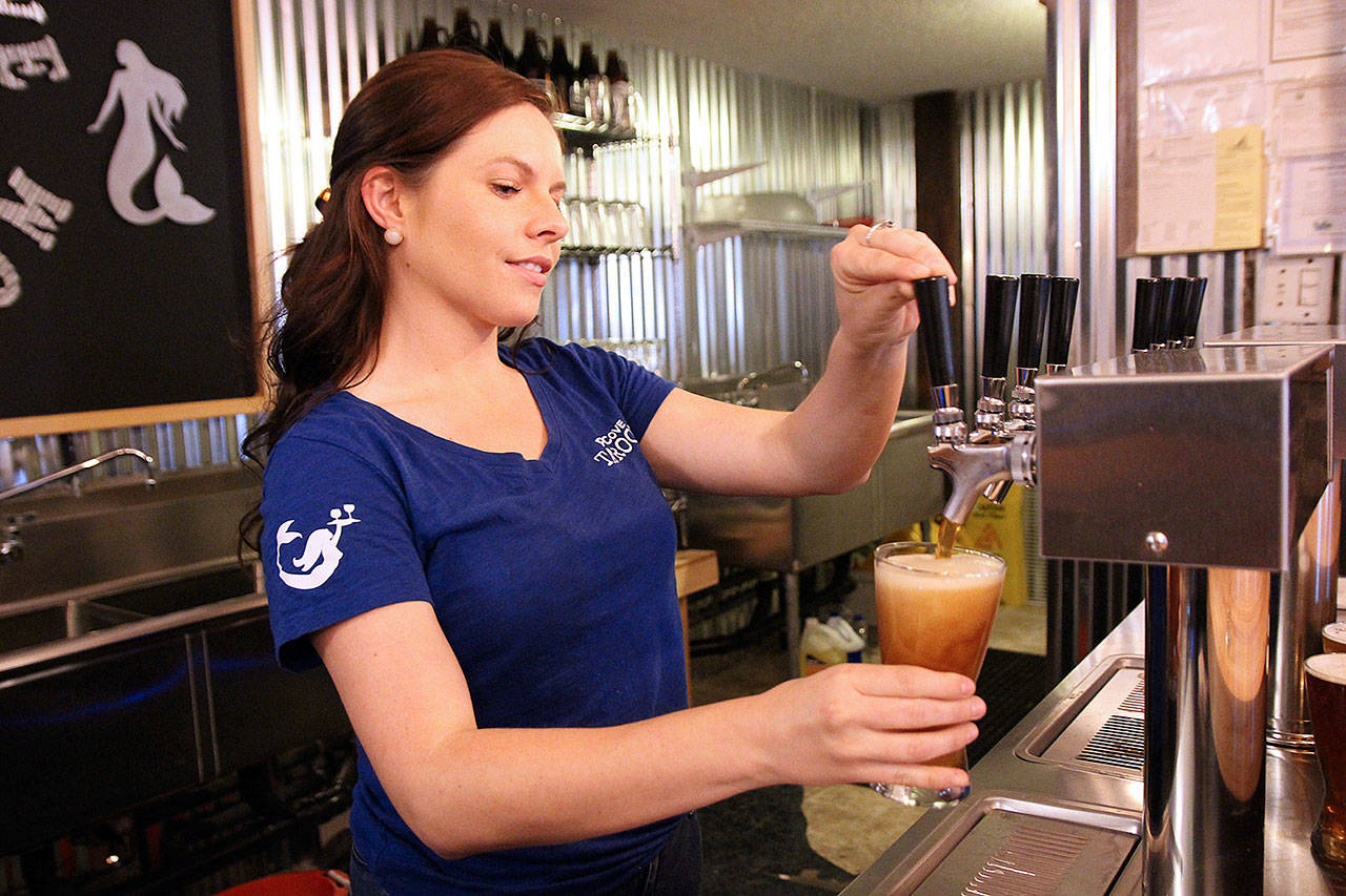 Hannah Gibbons pours a beer at Penn Cove Brewing Co.s new taproom in Oak Harbor. (Laura Guido/Whidbey News-Times)