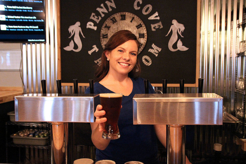 Hannah Gibbons serves a beer at Penn Cove Brewing Co.&rsquo;s new taproom in Oak Harbor. (Laura Guido/Whidbey News-Times)
