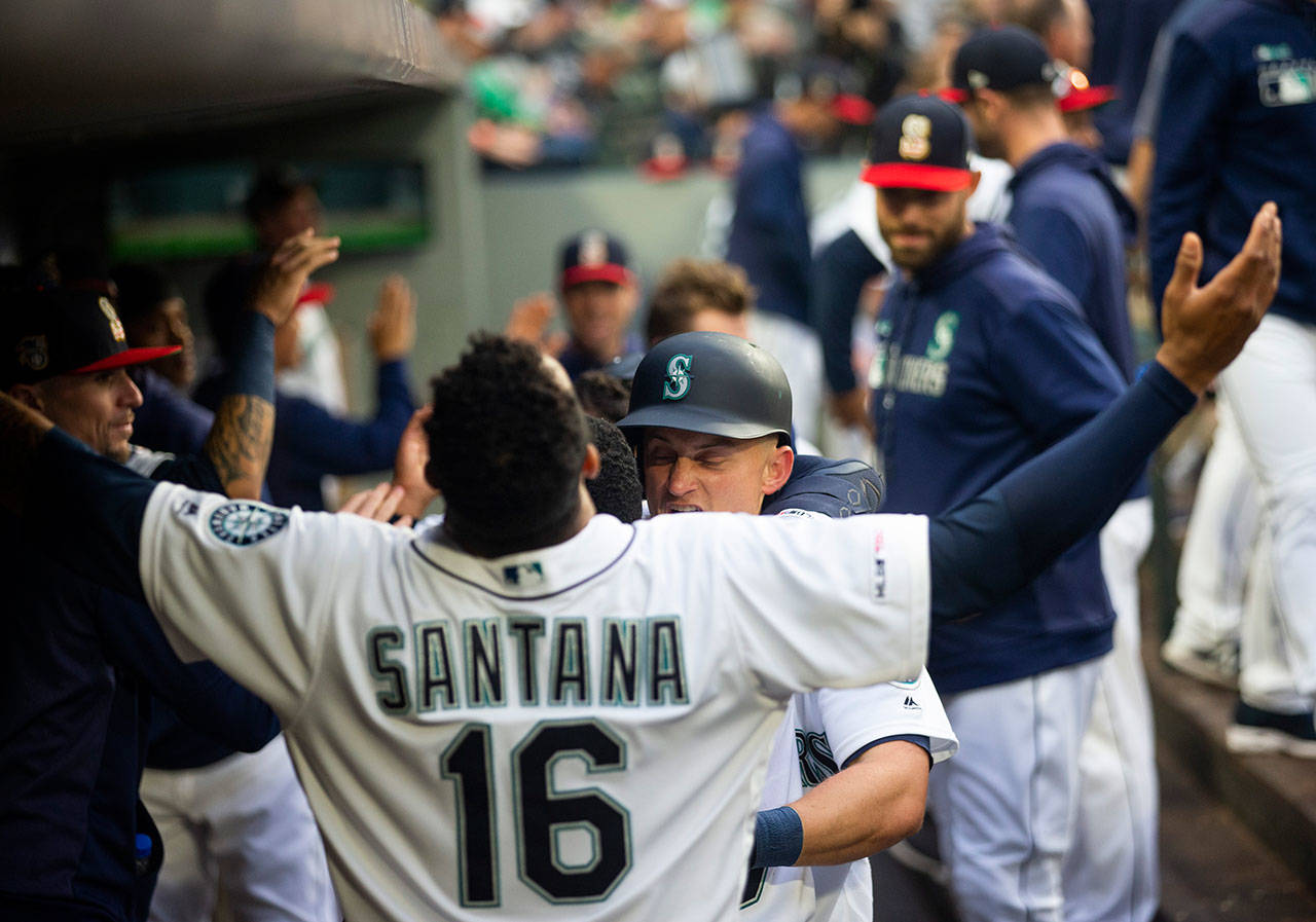 The Mariners’ Domingo Santana (16) welcomes Kyle Seager in the dugout after Seager hit a two-run home run during the fourth inning against the Athletics on July 6, 2019, in Seattle. (AP Photo/Lindsey Wasson)