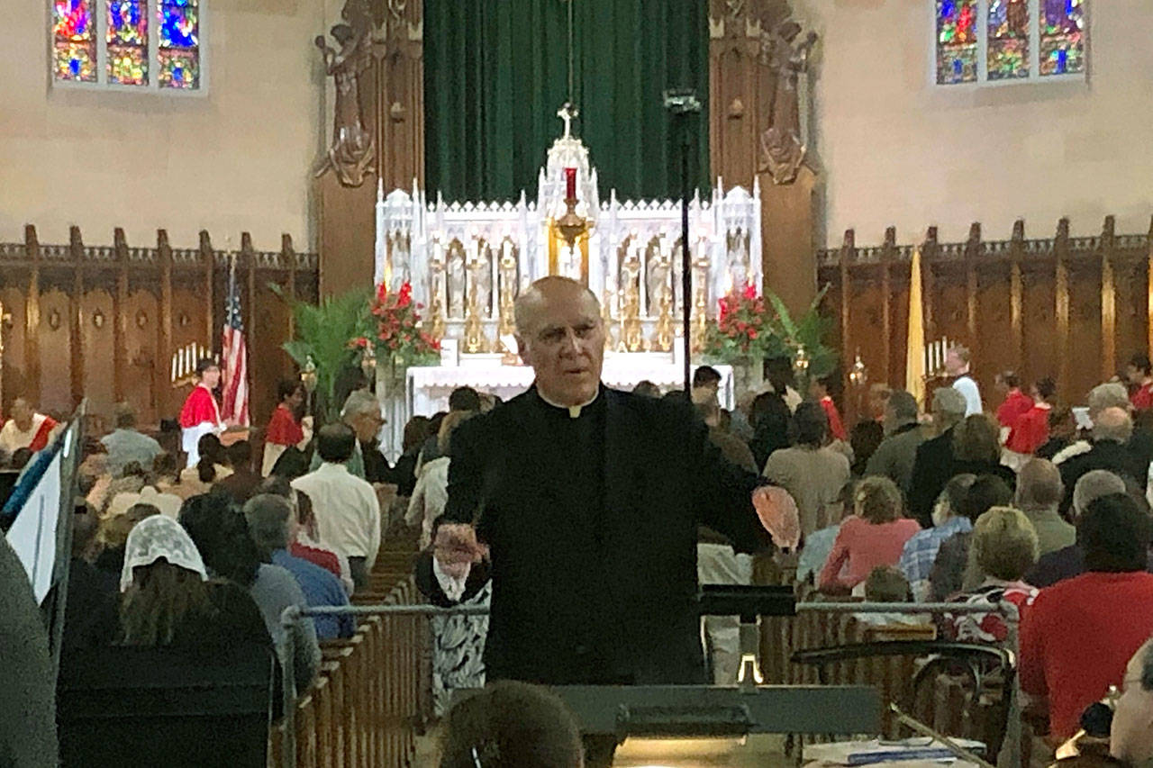 Father Eduard Perrone conducts a choir during mass at Assumption of the Blessed Virgin March Parish in Detroit on June 9. The Roman Catholic Archdiocese of Detroit said Sunday that it has removed Perrone from public ministry after receiving what it described as a “credible allegation” that he had abused a child decades ago. (AP Photo/Paul Sancya)