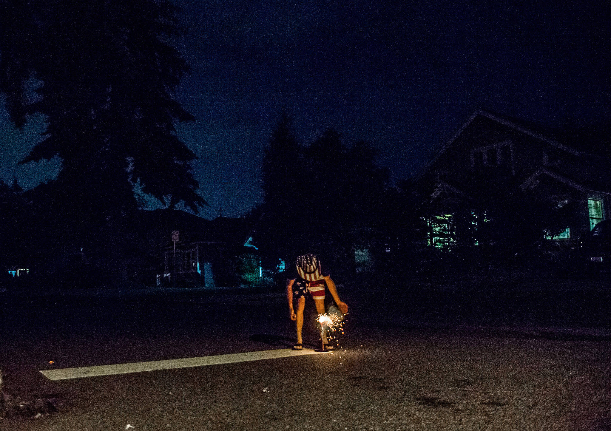 A boy lights fireworks in the Pinehurst neighborhood of Everett on July 4, 2018. (Olivia Vanni / The Herald)