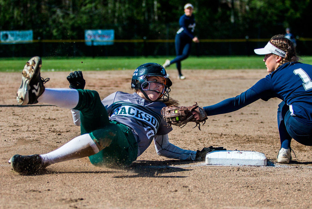 Jackson’s Macy Tarbox safely slides into third base while Glacier Peak’s Harlee Carpenter reaches out to tag her during a game at Jackson High School on April 24 in Mill Creek. (Olivia Vanni / The Herald)
