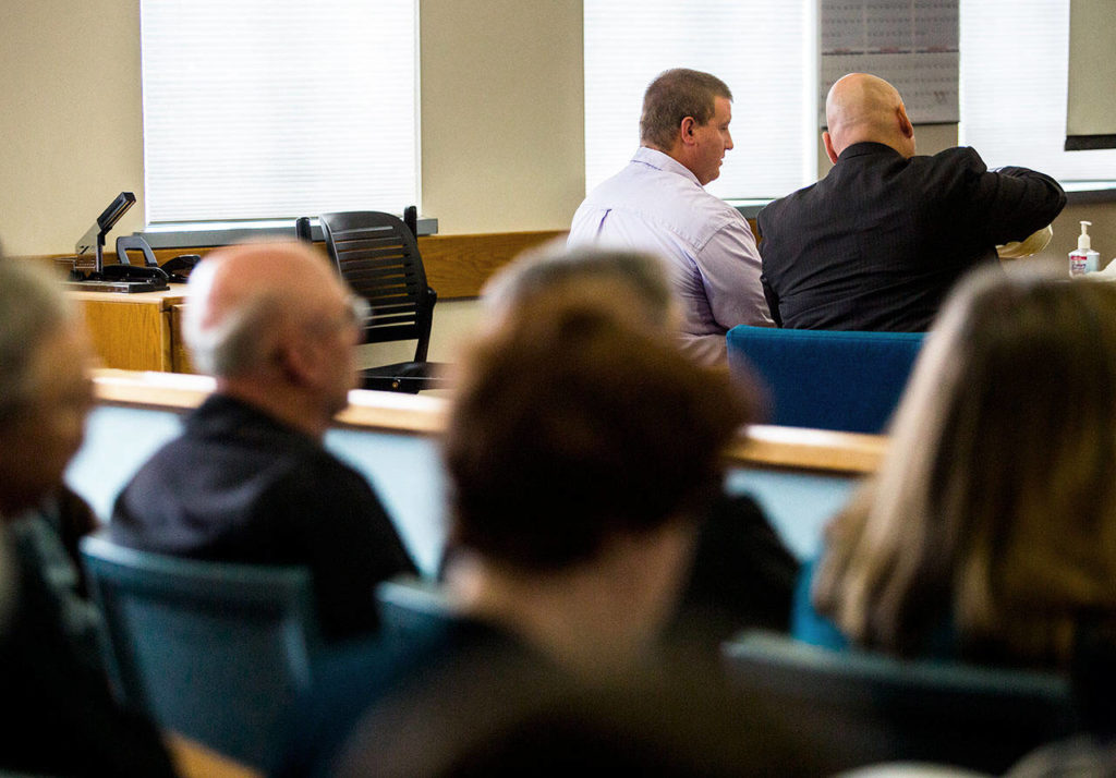 Michael Spieker (left) talks with attorney Jon Scott (right) during the closing arguments of Spieker’s trial on May 16 in Everett. (Olivia Vanni / Herald file)
