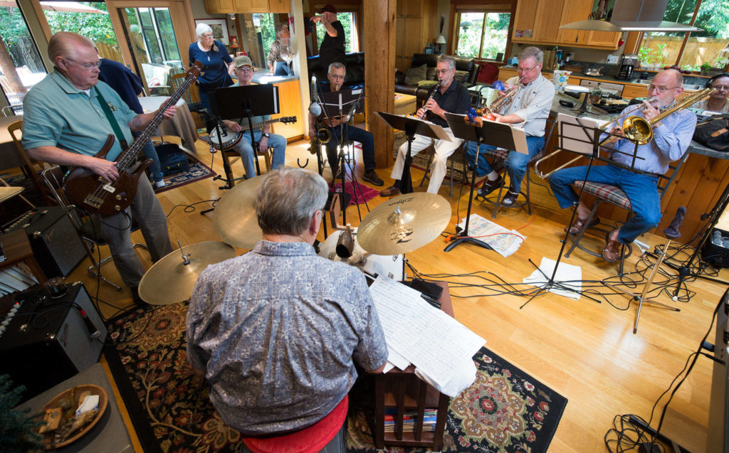 Members of the Ivy Five and friends play at the Edmonds home of Gary Ostlund (second from right on trumpet) on July 12. In 1956, five guys from Everett Junior High started the combo band to play in the school talent show. Those who live locally still get together to play regularly. On this date, Karner Trethewey (right, on trombone) was visiting from California so they held a special jam. (Andy Bronson / The Herald)
