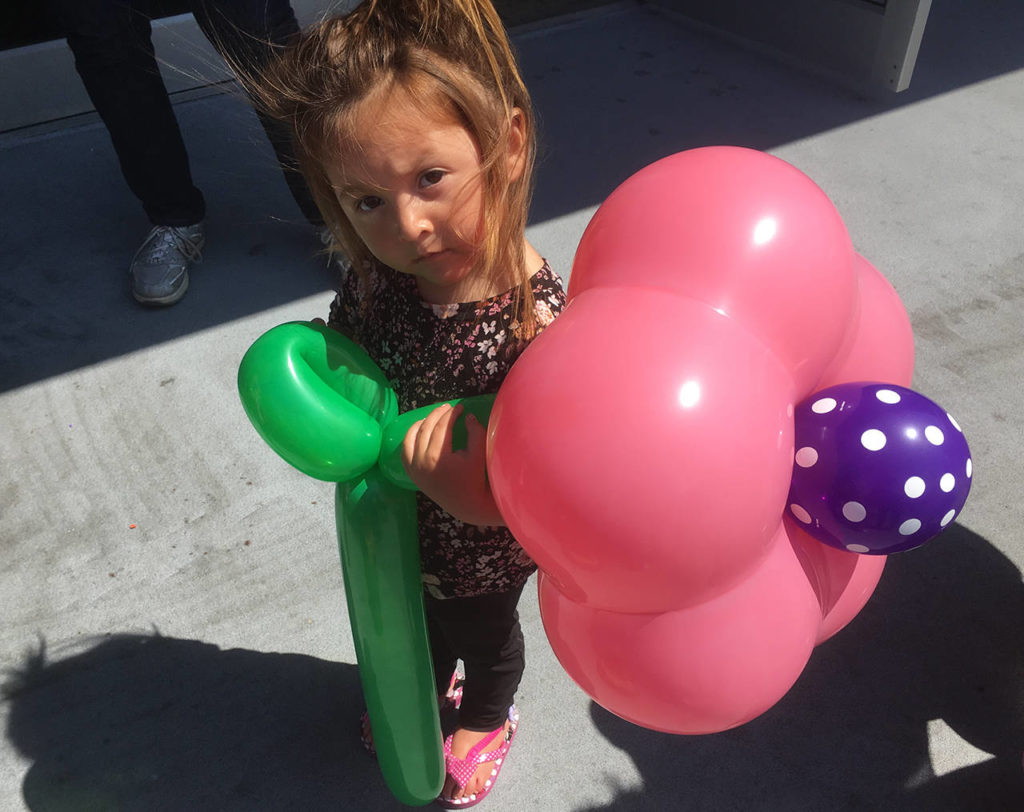 Aunalise Juarez, almost 3, of Everett, holds onto her giant balloon flower at the Everett Public Library on Saturday. (Sue Misao / The Herald)
