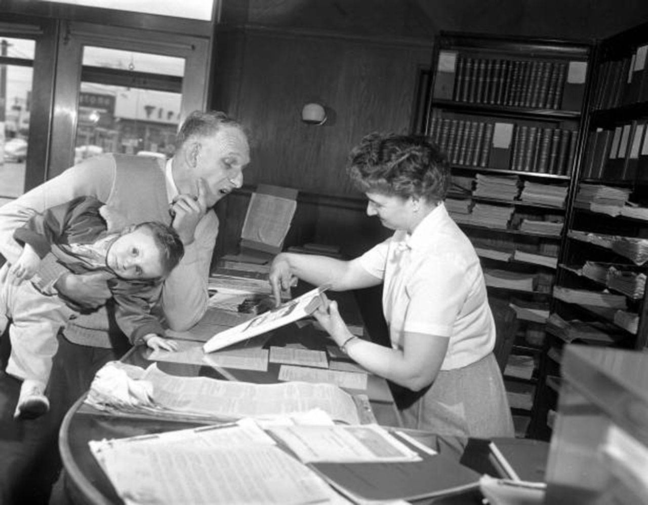 A librarian helps a patron at the library in 1956. (Everett Public Library)