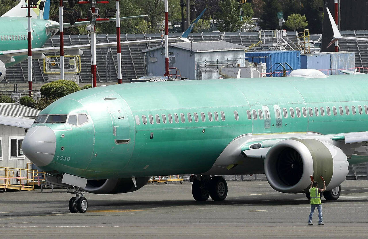 In this May 8 photo, a worker stands near a Boeing 737 MAX 8 jetliner being built for American Airlines prior to a test flight in Renton. United Airlines said Friday that it now expects to cancel more than 8,000 flights through October because of the grounding of its Boeing 737 Max planes. (AP Photo/Ted S. Warren, File)