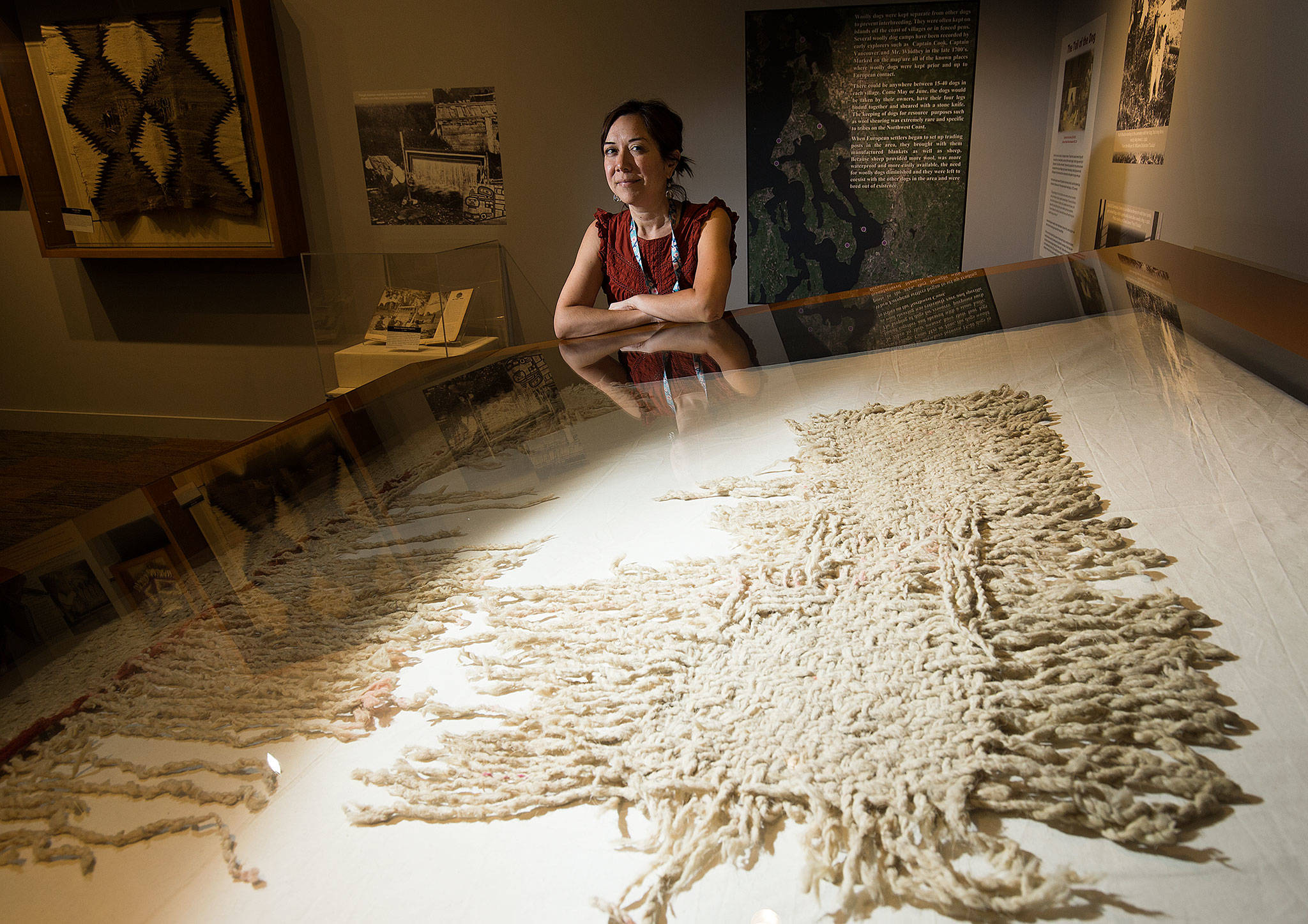 Senior curator Tessa Campbell with a rare example of a blanket made from woolly dog hair and mountain goat hair at the Hibulb Cultural Center in Tulalip. The blanket is part of the current exhibit “Interwoven History, Coast Salish Wool.” (Andy Bronson / The Herald)
