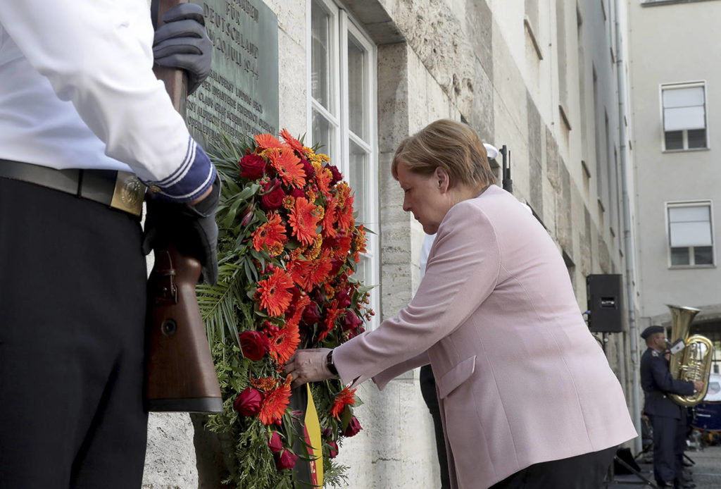 German Chancellor Angela Merkel adjusts a wreath during a memorial event at the Defence Ministry in Berlin, Germany on Saturday. (AP Photo/Michael Sohn)
