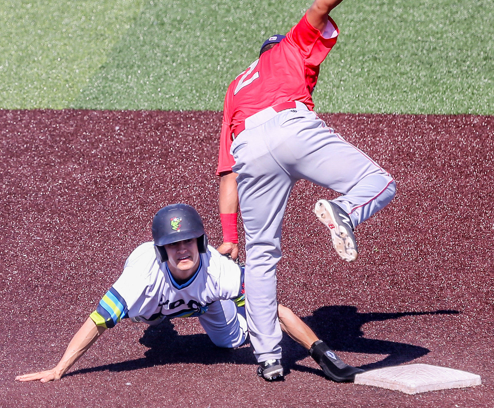 Everett’s Billy Cooke is tagged out by Spokane’s Christian Inoa on Sunday afternoon at Funko Field at Everett Memorial Stadium. (Kevin Clark / The Herald)