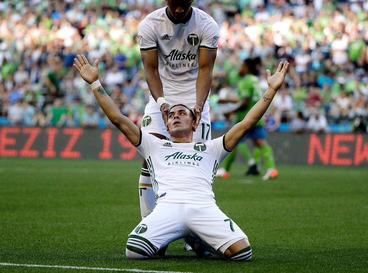 Portland Timbers forward Brian Fernandez (front) celebrates with Jeremy Ebobisse after Fernandez scored a goal against the Seattle Sounders in the first half of their MLS soccer match Sunday in Seattle. Fernandez scored twice in the Timbers’ 2-1 win. (AP Photo/Ted S. Warren)