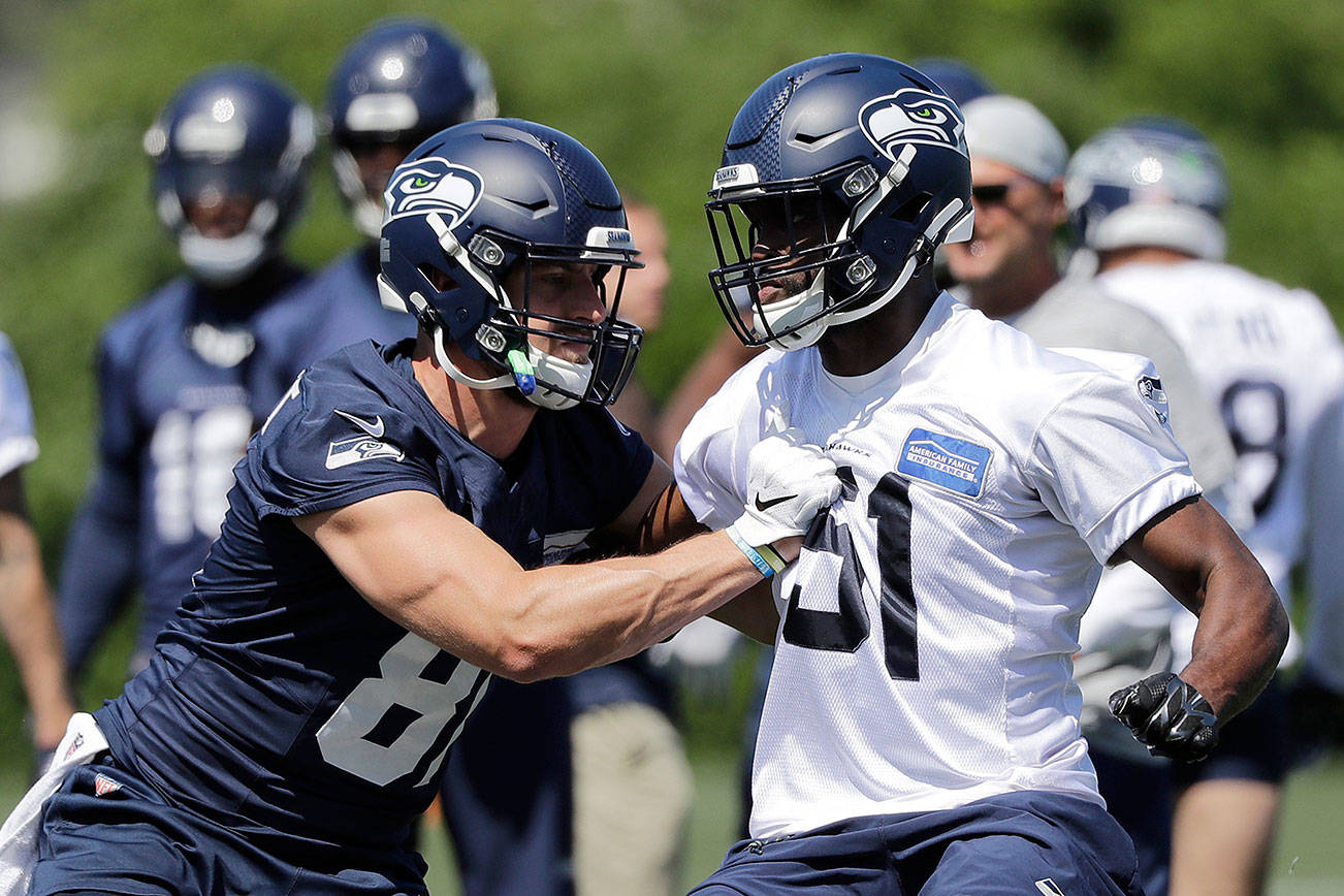 Seattle Seahawks tight end Nick Vannett, left, pushes against Barkevious Mingo during a practice Thursday, June 13, 2019, at the team’s NFL football training facility in Renton, Wash. (AP Photo/Elaine Thompson)