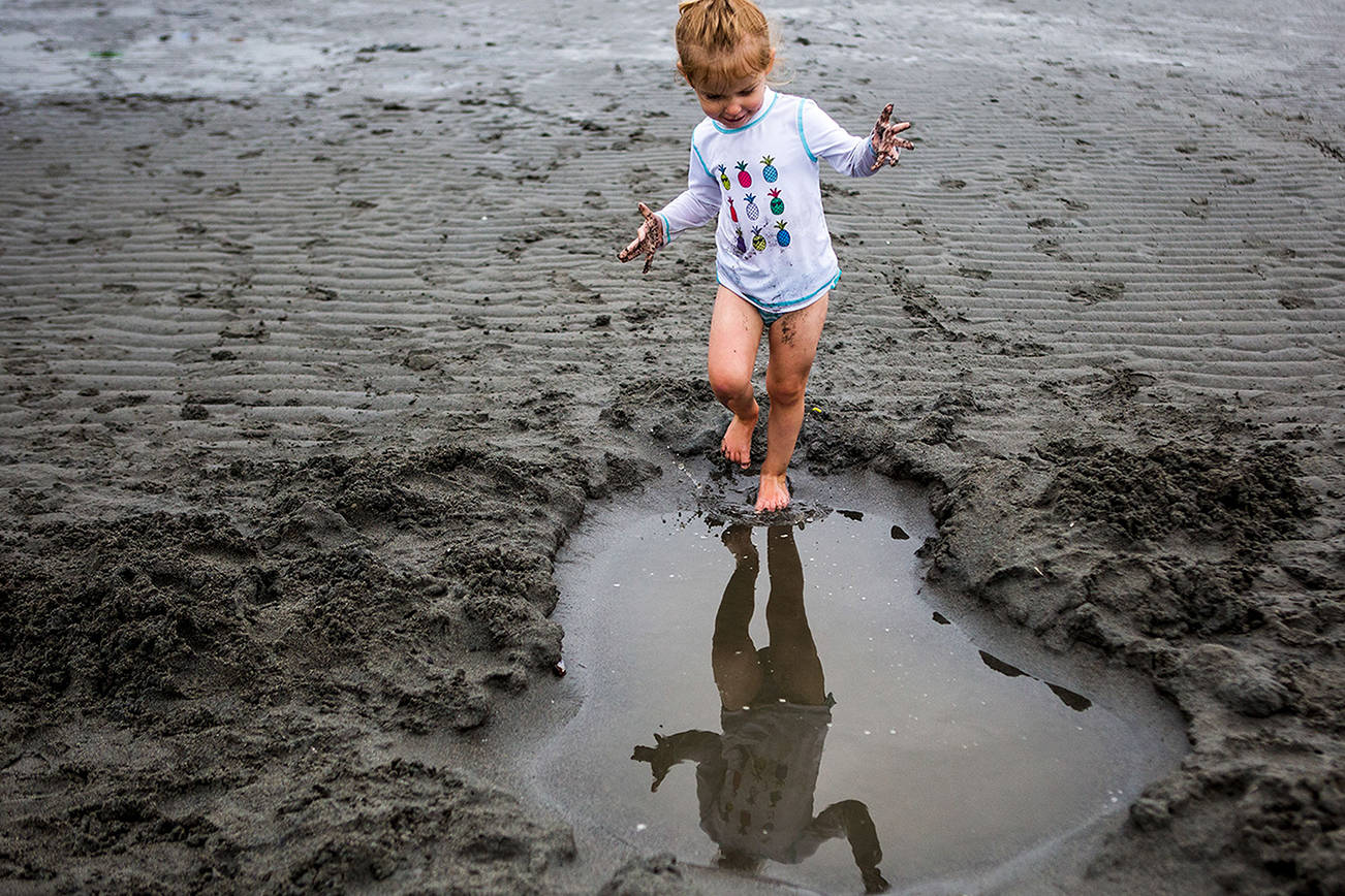 Ella Hall, 2, splashes in a large water hole out on the tide flats during opening day of Jetty Island on Friday, July 5, 2019 in Everett, Wash. (Olivia Vanni / The Herald)