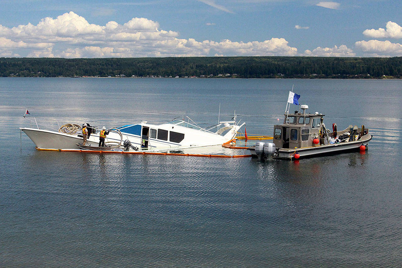 Global Diving and Salvage works to get the 65-foot yacht “Silver Lining” floating Wednesday. The yacht struck an unknown object and partially sank Tuesday night near the Hood Canal Bridge. (Zach Jablonski / Peninsula Daily News)