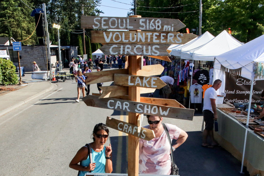A signpost directs fair goers to the different available venues Friday afternoon during Lake Stevens’ Aquafest. (Kevin Clark / The Herald)
