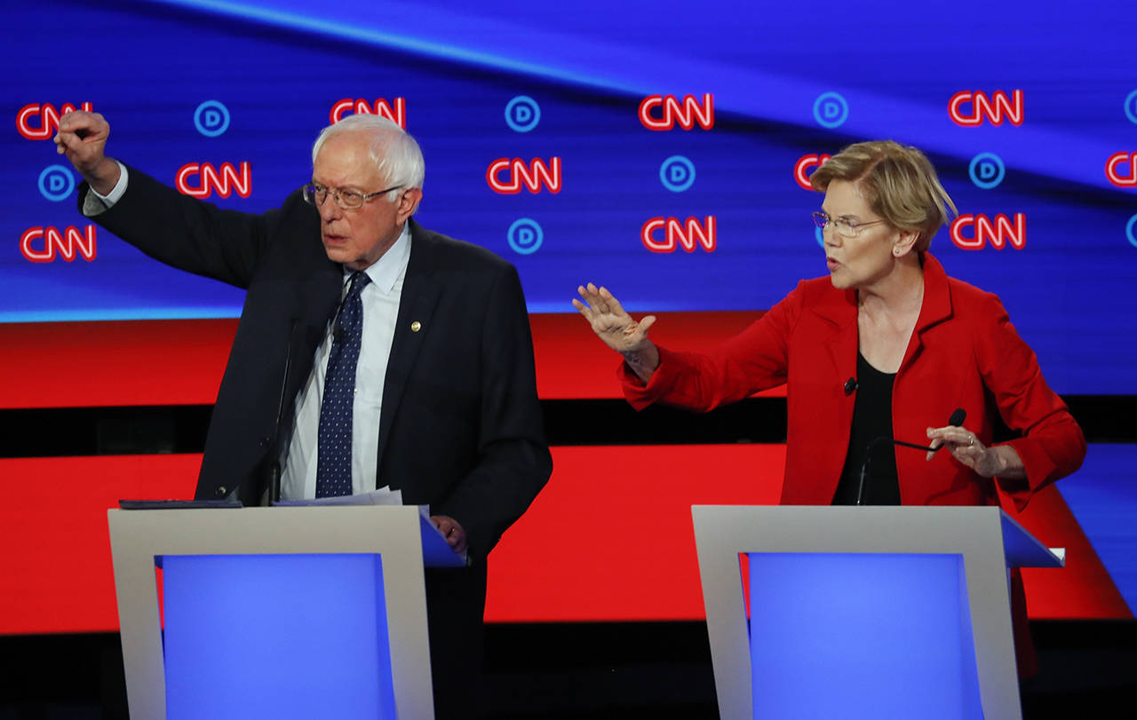 Sen. Bernie Sanders, I-Vt., and Sen. Elizabeth Warren, D-Mass., talk during in the first of two Democratic presidential primary debates hosted by CNN on Tuesday in the Fox Theatre in Detroit. (AP Photo/Paul Sancya)