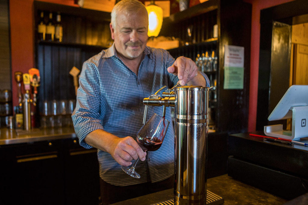 Jeff Wicklund fills a wine glass from the tap at Cafe Zippy’s new wine bar, C. Vines, in Everett. (Olivia Vanni / The Herald) 
