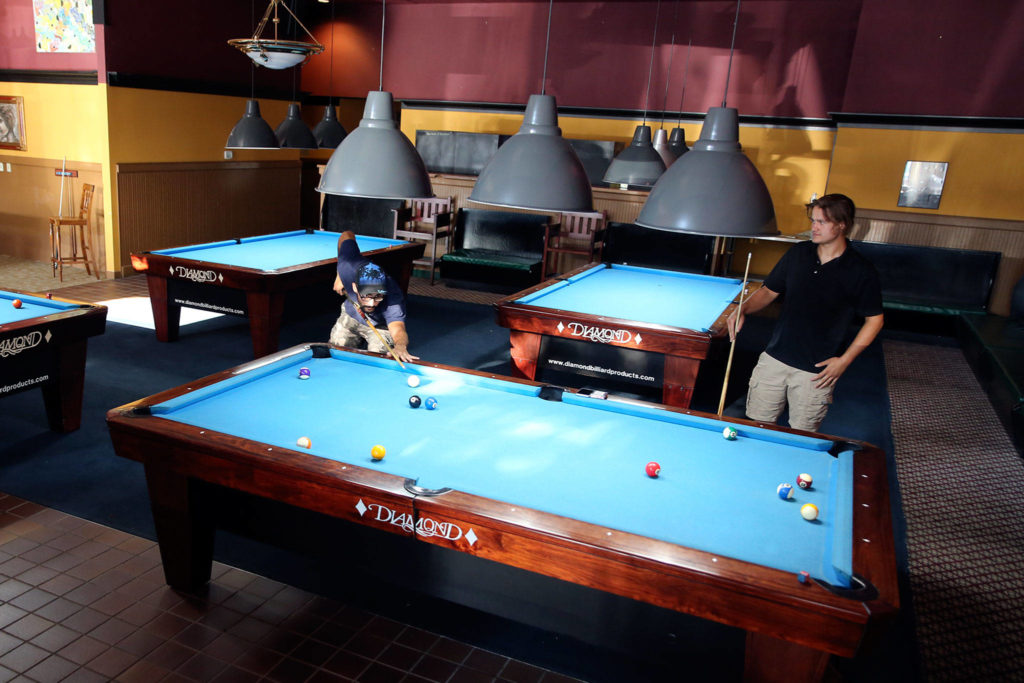 Wilker Leite (left) and Chris Corisa play a game at Golden Fleece Billiards in Everett. (Kevin Clark / The Herald)
