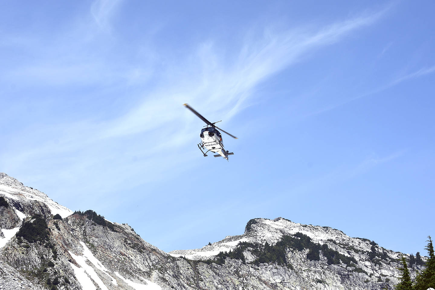 A helicopter crew scours rough terrain Sunday, Aug. 5, at Vesper Peak, in the search for missing hiker Sam Sayers, of Seattle. She went missing Aug. 1, on the hike about 30 miles east of Granite Falls. (Caleb Hutton / The Herald)