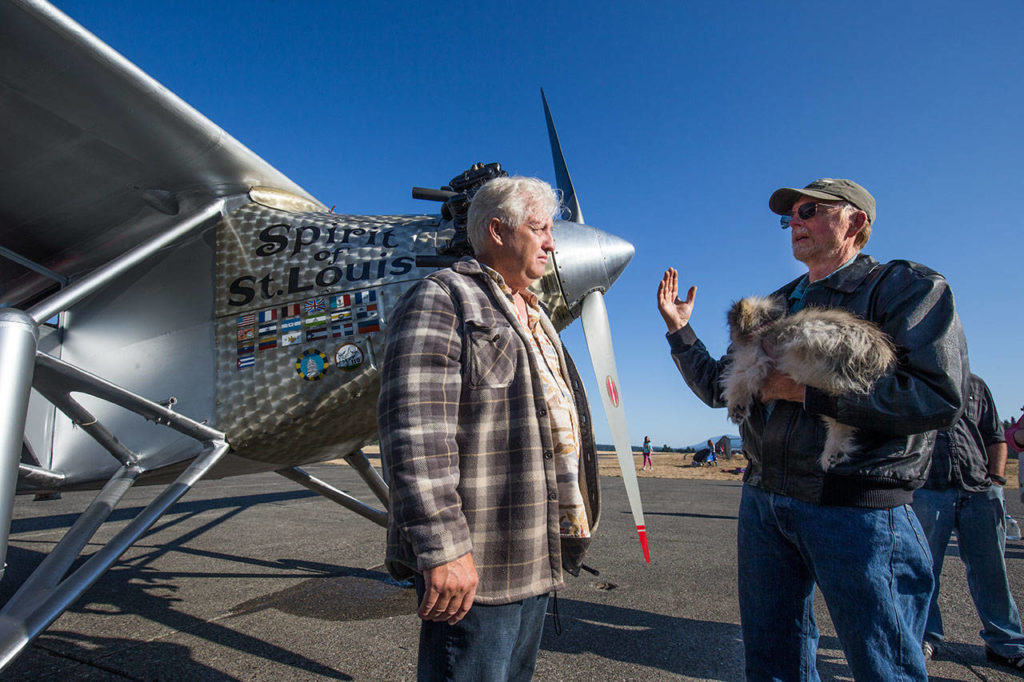 John Norman listens as pilot Ron Fowler explains what happened during the first flight of Norman’s replica of the Spirit of St. Louis from Arlington Municipal Airport on July 28. (Andy Bronson / The Herald)
