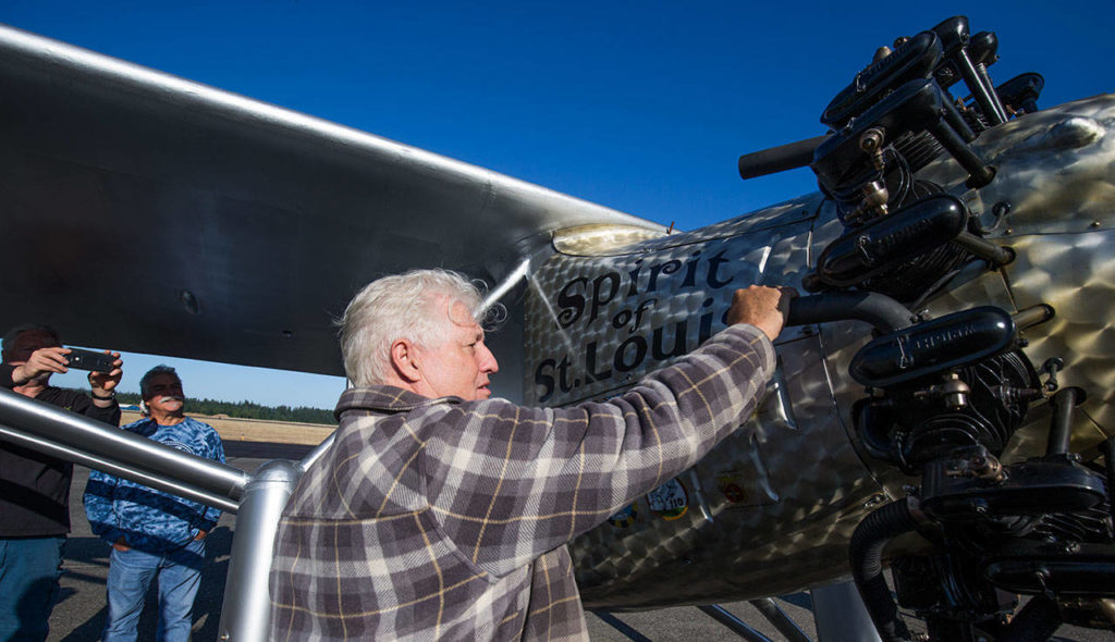 John Norman’s grabs hold of a cold exhaust pipe after the first flight of his replica airplane, the Spirit of St. Louis, from Arlington Municipal Airport on July 28. A couple cylinders on the engine misfired and were cold at the end of the flight, meaning he’ll have figure out why they did not work. (Andy Bronson / The Herald)
