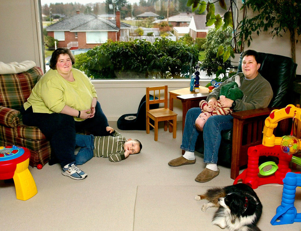 In March 2002, Betsy Davis (left) keeps her 3-year-old son Ian in check while her partner at that time, Amy Leonard, balances their 11-month-old, Sam, on her lap in their Everett home. Ian Davis-Leonard has been The Herald’s news intern this summer. (Michael O’Leary / Former Herald Staff)
