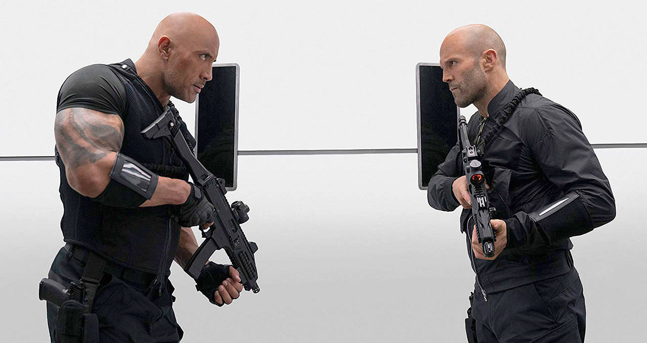 Dwayne Johnson (left) and Jason Statham play a couple of muscle-bound bald guys who don’t like each other in “Fast & Furious Presents: Hobbs & Shaw.” (Universal Pictures)