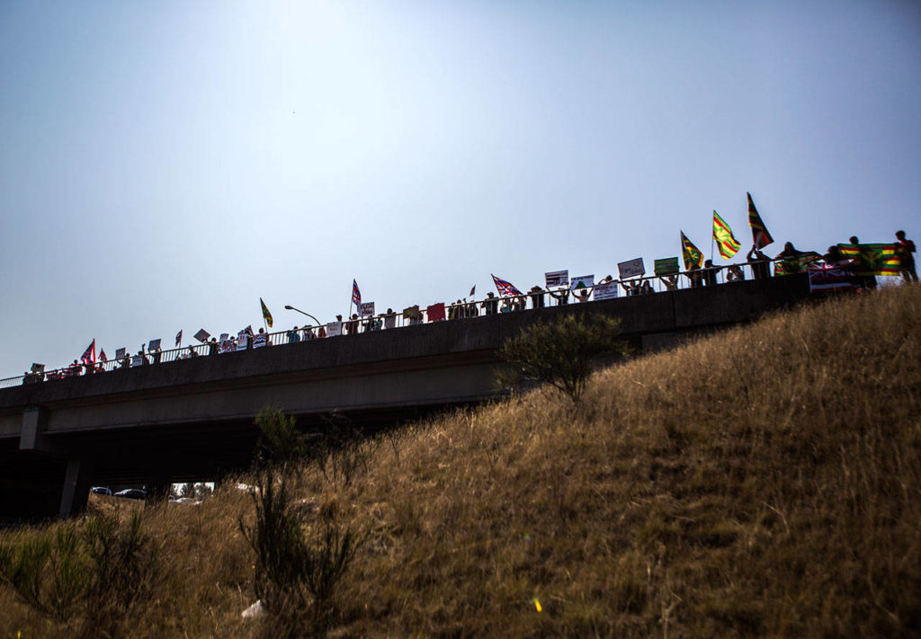 Hundreds gather along the I-5 overpass between Marysville and Quil Ceda in protest Saturday in Marysville. (Olivia Vanni / The Herald)
