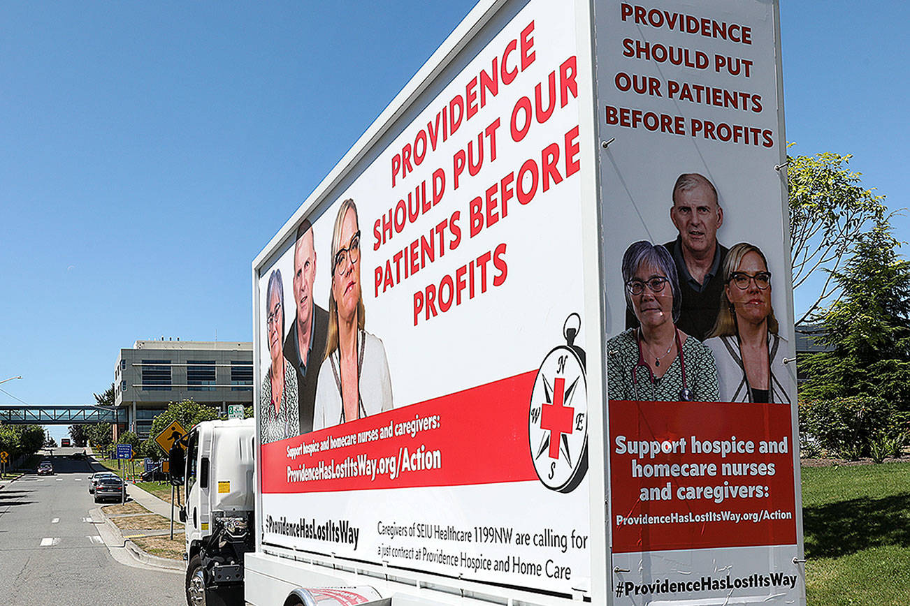 Hospice workers with Providence Hospice and Homecare of Snohomish County launched a billboard campaign in Everett calling for the organization to put patients before executive pay. (Lizz Giordano / The Herald)