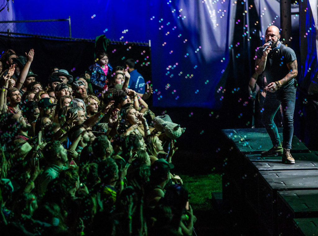 Nahko Bear of Nahko And Medicine For The People stands on the MainStage speakers and sings during the first day of Summer Meltdown on Thursday, Aug. 1, 2019 in Darrington, Wash. (Olivia Vanni / The Herald)
