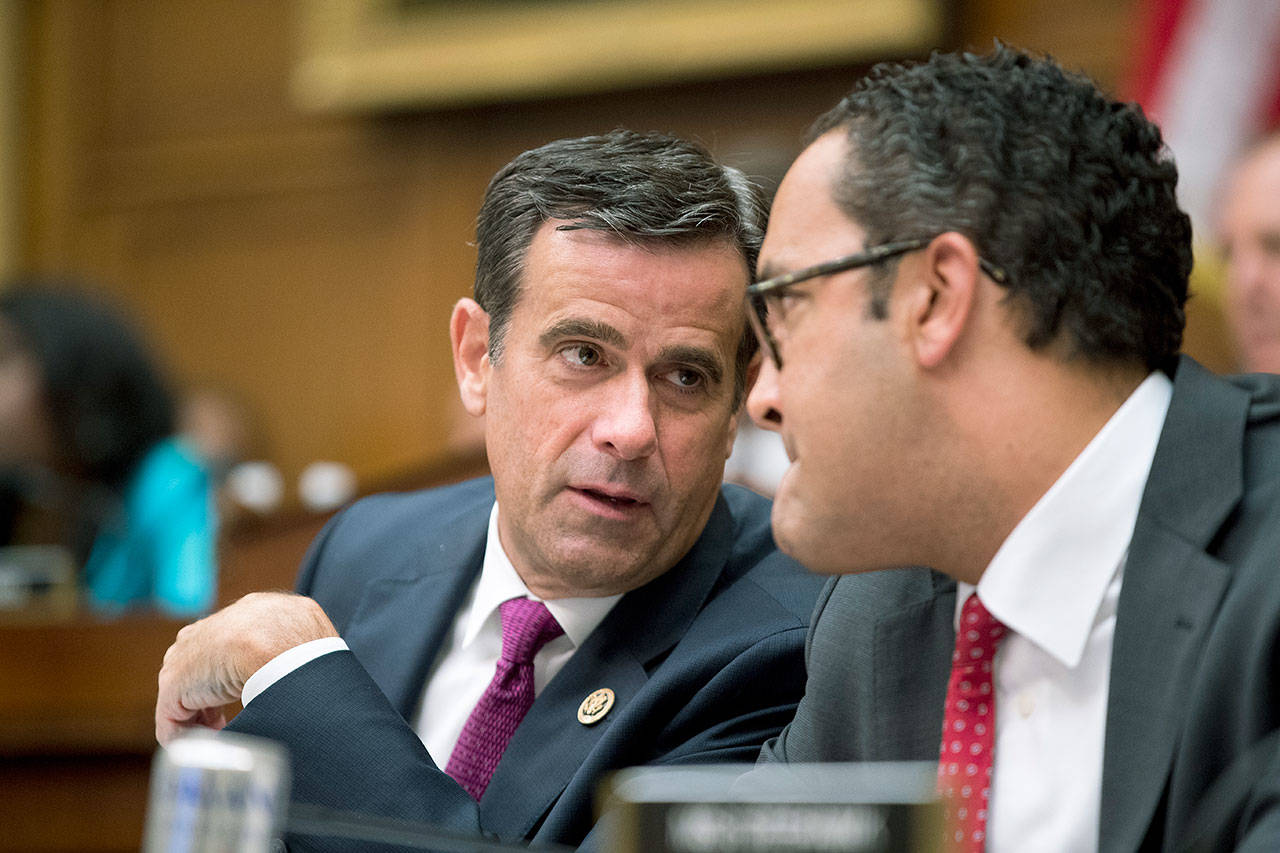 Rep. John Ratcliffe (left), R-Texas, and Rep. Will Hurd, R-Texas, confer as former special counsel Robert Mueller appears before a House Intelligence Committee hearing July 24 on Capitol Hill on his report detailing Russian election interference. (AP Photo/Andrew Harnik)