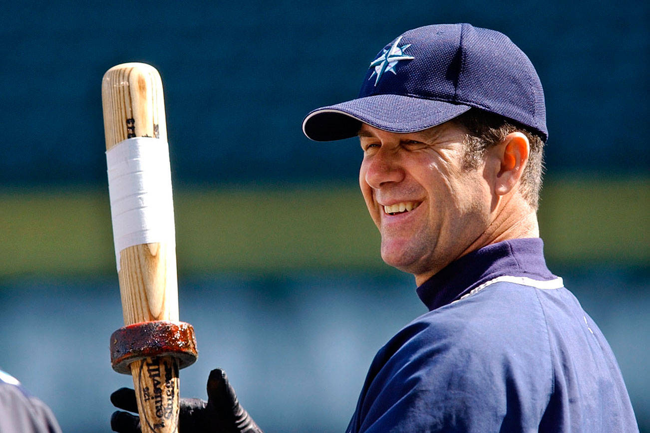 In this April 5, 2004, file photo, Seattle Mariners designated hitter Edgar Martinez, right, chats with trainer Rick Griffin during practice in Seattle. (AP Photo/Elaine Thompson, File)