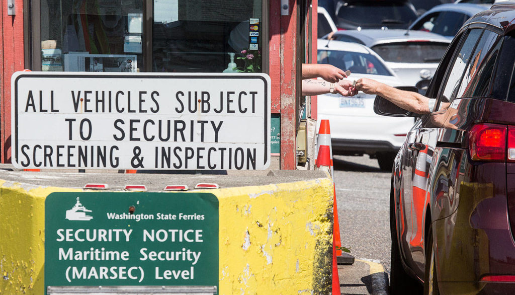 A passenger pays a toll at the Mukilteo ferry dock tool booth on Tuesday, Aug. 6, 2019 in Mukilteo, Wa. The Washington State Transportation Commissioners on Tuesday approved all of the proposed ferry rate increases for passengers and cars. (Andy Bronson / The Herald )

