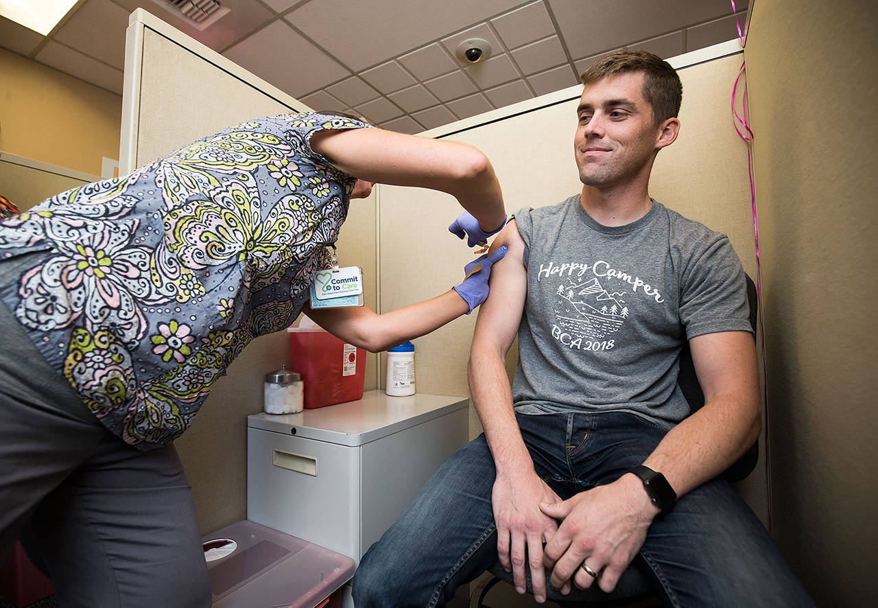 Rocky Oliphant gets a flu shot at the Everett Clinic in 2018 in Everett. (Andy Bronson / Herald file)
