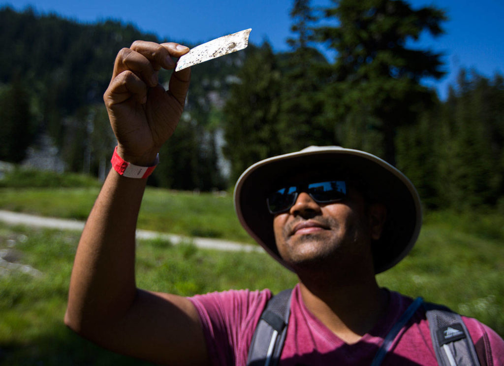 Sanjog Patel holds an old and faded ski pass he found during the annual Stevens Pass cleanup. (Olivia Vanni / The Herald)
