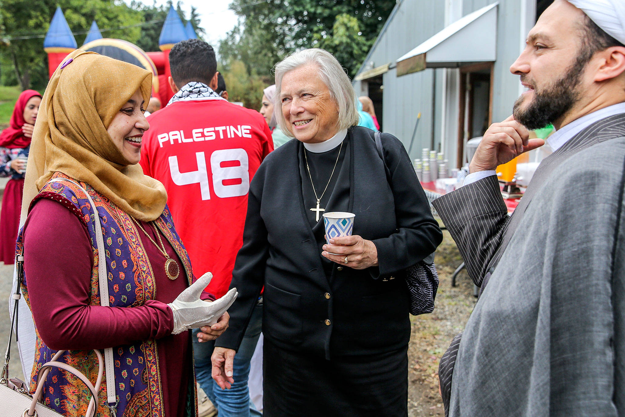 Zahra Abidi (left), of the Husayniah Islamic Society of Seattle, retired pastor Janice Nesse and guest Imam Rasoul Naghavi visit Sunday morning at a block party and potluck in Snohomish that was hosted by the organization. (Kevin Clark / The Herald)