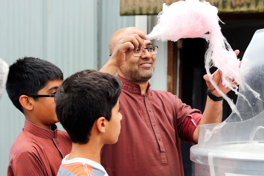 Masroor Syed gathers cotton candy Sunday morning at a block party hosted by the Husayniah Islamic Society of Seattle in Snohomish. (Kevin Clark / The Herald)
