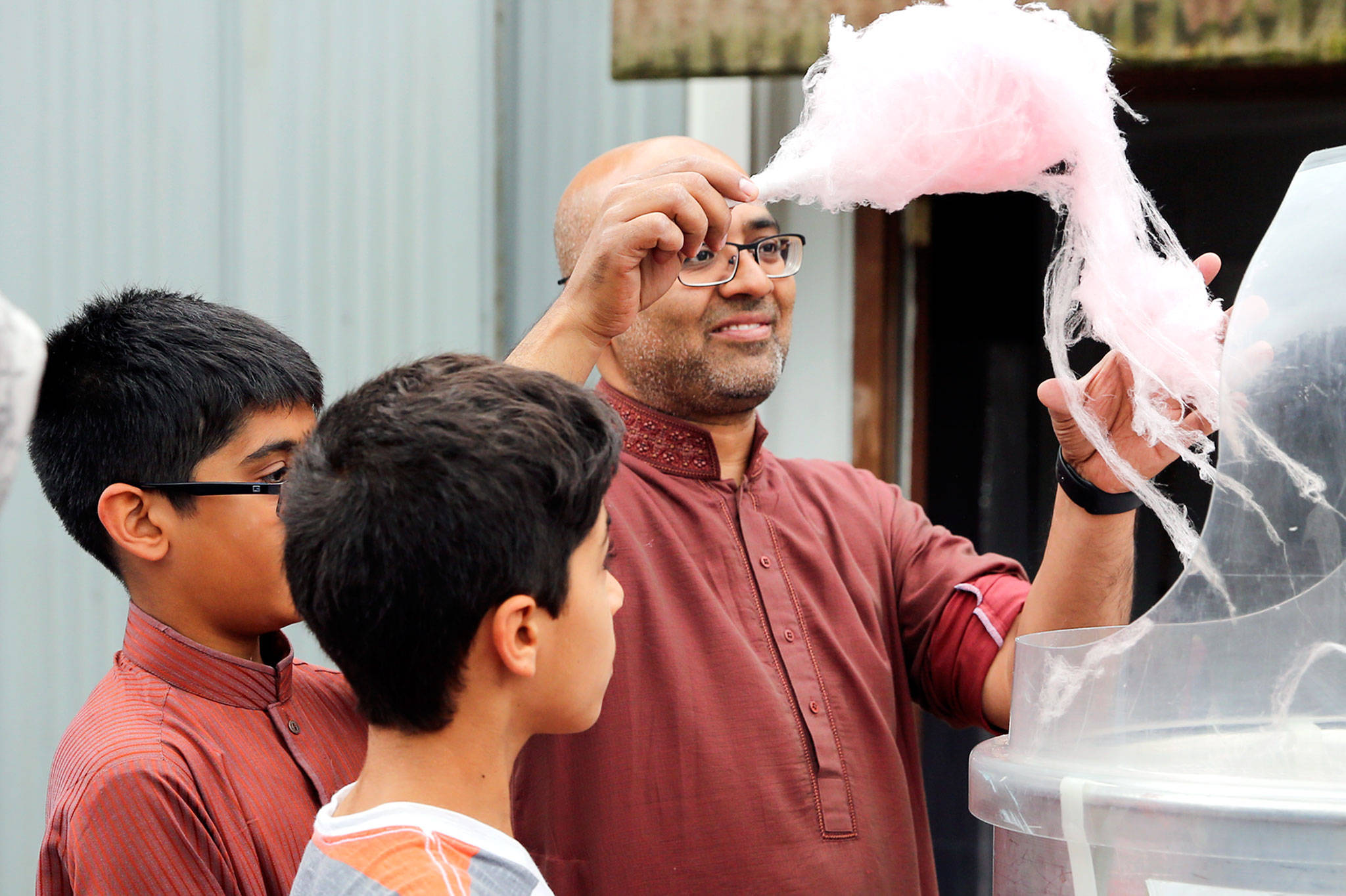 Masroor Syed gathers cotton candy Sunday morning at a block party hosted by the Husayniah Islamic Society of Seattle in Snohomish. (Kevin Clark / The Herald)