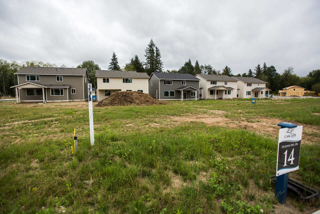 Newly constructed Cascade Breeze homes sit next undeveloped lots as a new home is constructed in the background on Thursday in Sultan. (Olivia Vanni / The Herald)
