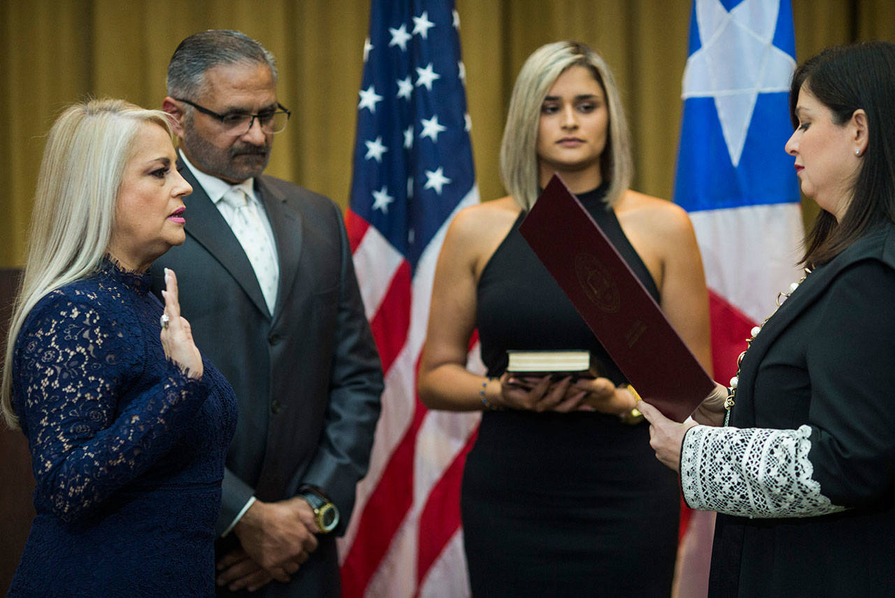 Justice Secretary Wanda Vazquez is sworn in as governor of Puerto Rico on Wednesday by Supreme Court Justice Maite Oronoz, in San Juan, Puerto Rico. Vazquez took the oath of office early Wednesday evening at the Puerto Rican Supreme Court, which earlier in the day ruled that Pedro Pierluisi’s swearing in last week was unconstitutional. Vazquez was joined by her daughter Beatriz Diaz Vazquez and her husband Judge Jorge Diaz. (AP Photo/Dennis M. Rivera Pichardo)