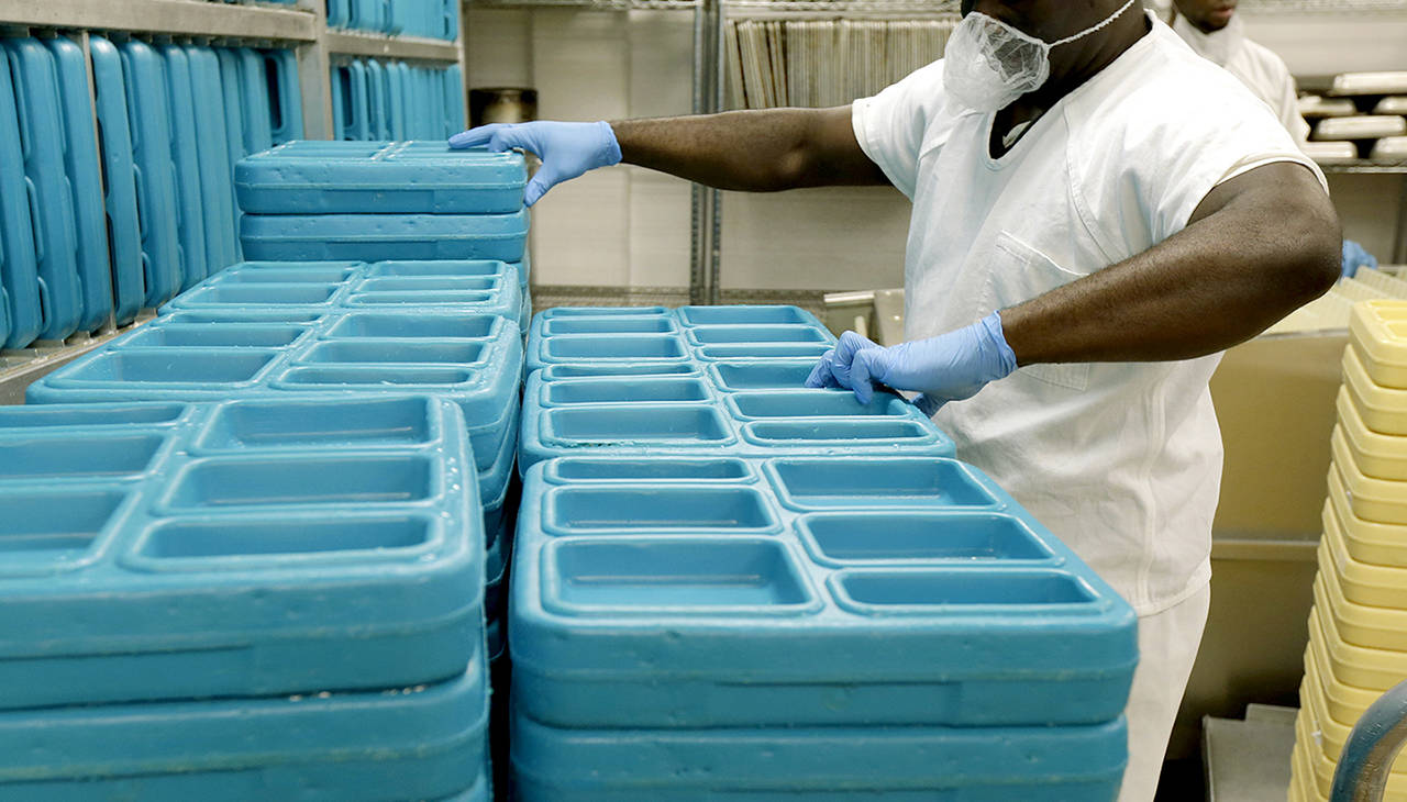 In this 2017 photo, a detainee works in the kitchen of the Northwest Detention Center in Tacoma, during a media tour of the facility. (AP Photo/Ted S. Warren, file)