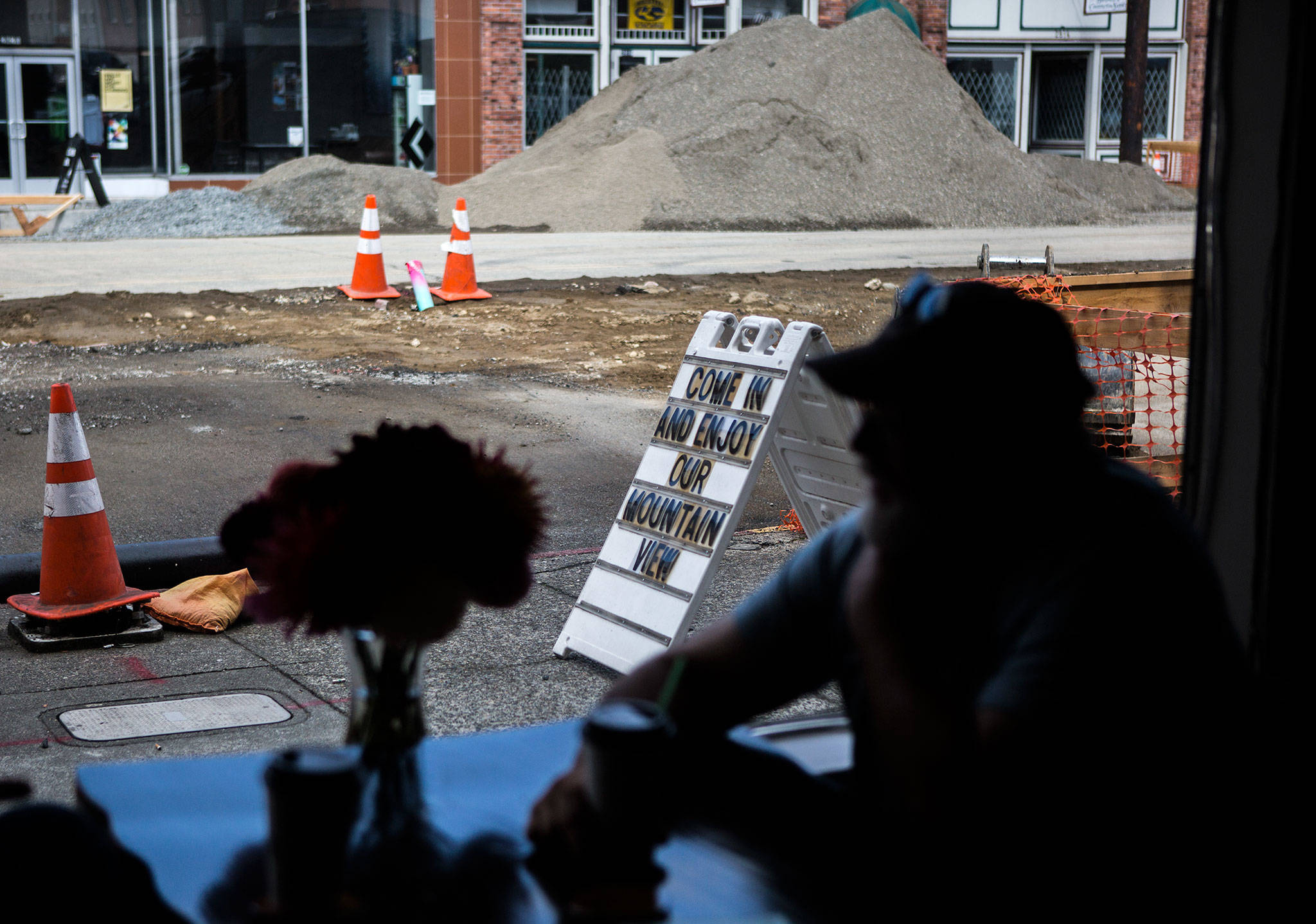 A sign outside Bargreen’s Coffee on Rucker Avenue pokes fun at the large pile of construction dirt. (Olivia Vanni / The Herald)