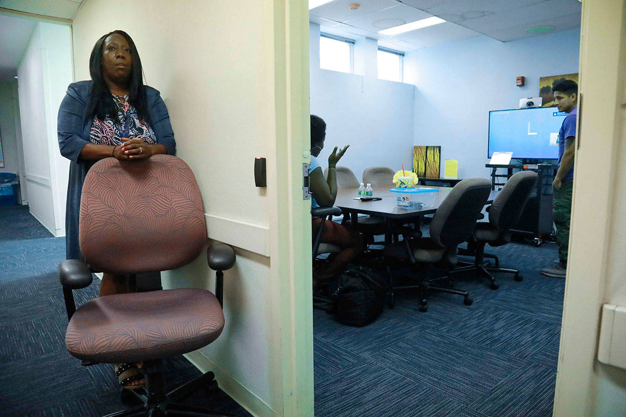 Kim McNeil-Capers, head of outreach programs at Queens Central Library, wait outside a room during setup of a videoconference between an incarcerated individual and a family member in Queens borough of New York. (AP Photo/Bebeto Matthews)