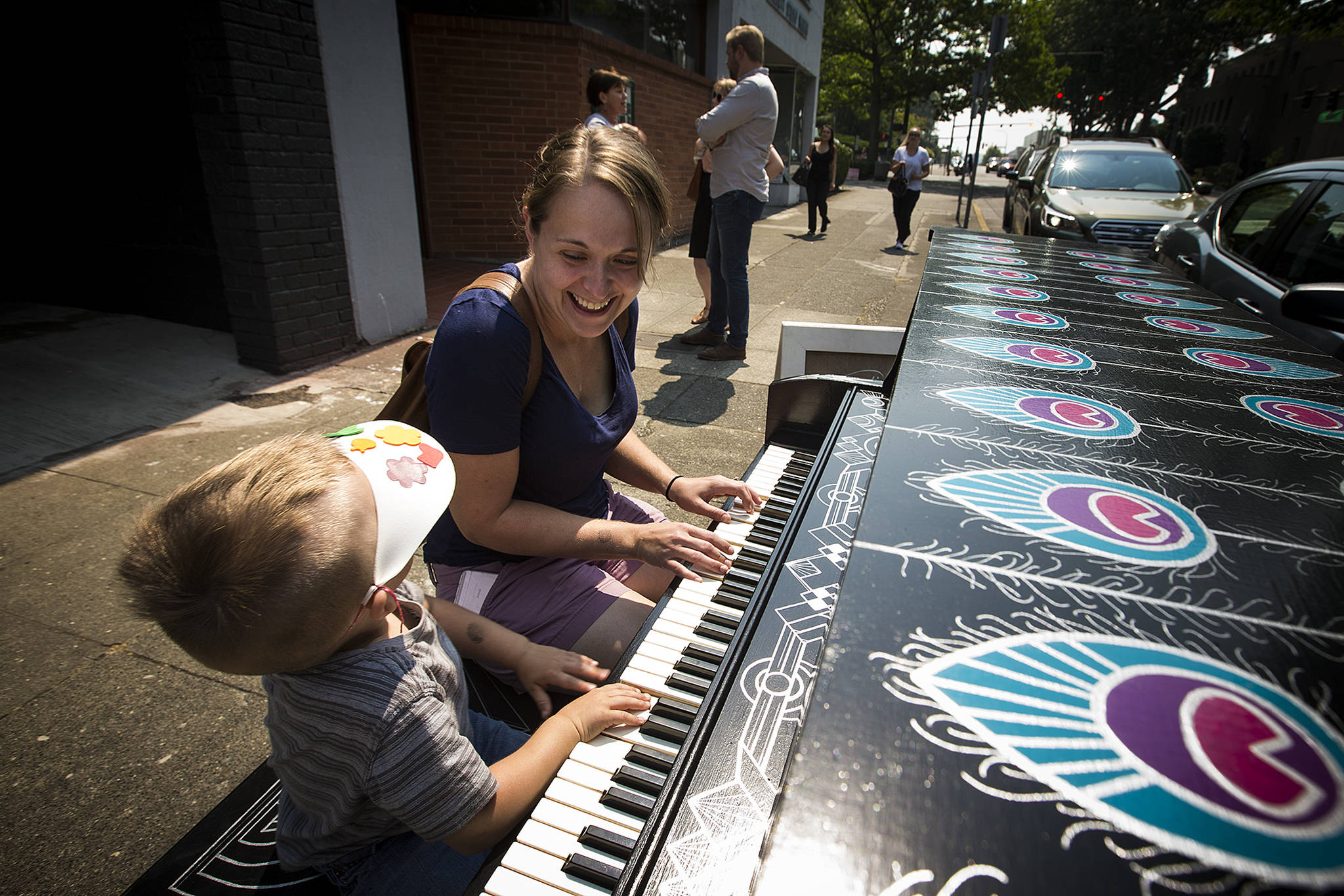 Julia Mooney, of Snohomish, plays a piano, titled “Live Your Song” by artist Rosemary Jones, outside Narrative Coffee in Everett in 2017. Sixteen pianos have been installed this year around downtown Everett for Street Tunes, which lasts until Aug. 27. (Ian Terry / Herald file)