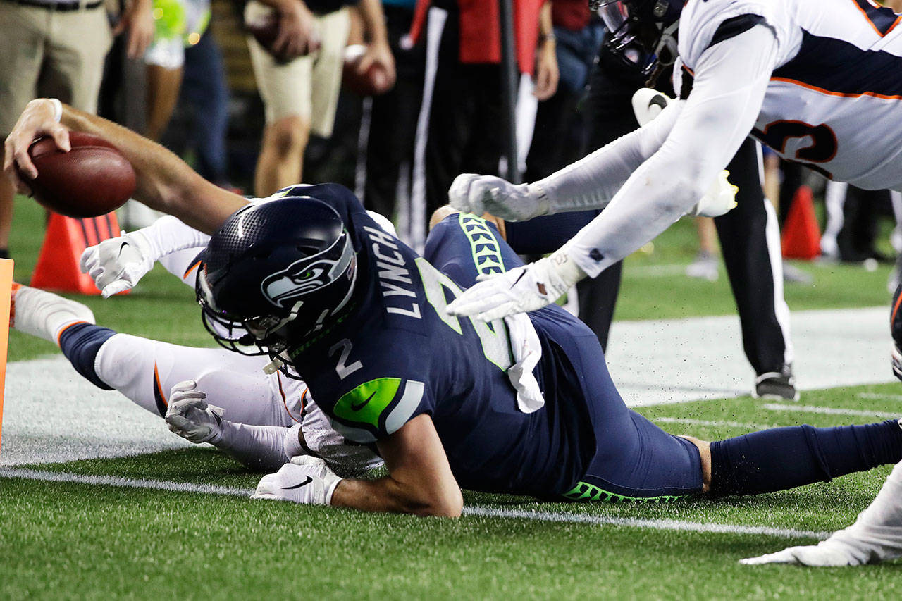 Seahawks quarterback Paxton Lynch reaches across the goal line to score a touchdown during a preseason game against the Broncos on Aug. 8, 2019, in Seattle. (AP Photo/Elaine Thompson)